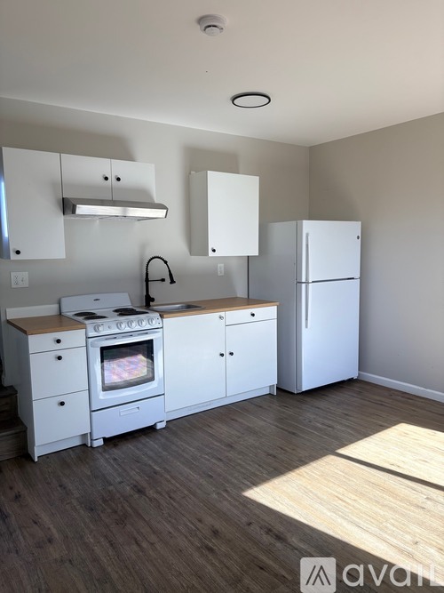 A kitchen with white appliances and cabinets.