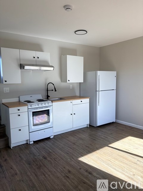 A kitchen with white appliances and cabinets.