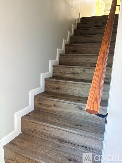 A wooden staircase with a white railing.