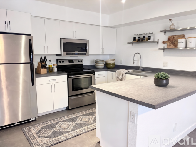 A modern kitchen with white cabinets and stainless steel appliances.