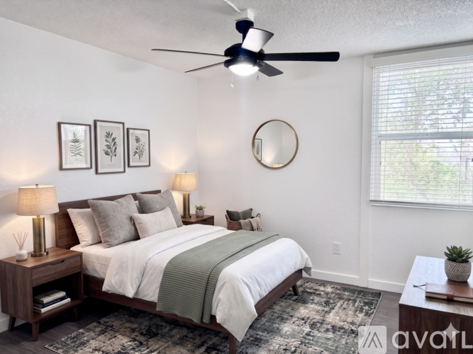 A bedroom with a bed, nightstand, and a ceiling fan.