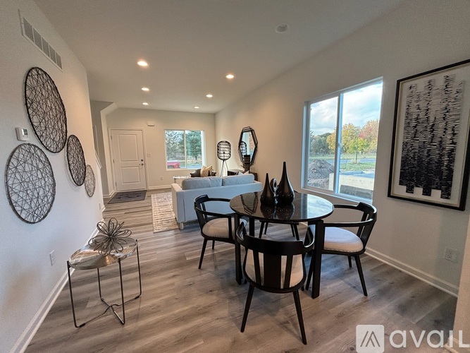 A dining room with a black table and chairs.