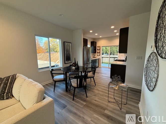 A modern living room with a black table and chairs.