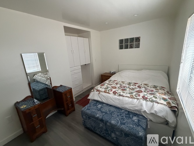 A bedroom with a bed, nightstand, and a mirror.