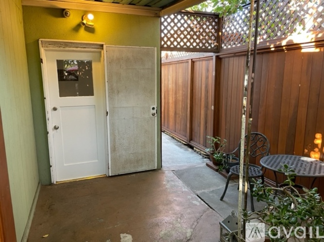 A patio with a table and chairs and a white door.