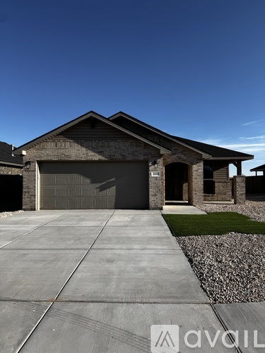 A house with a garage and a driveway in front.