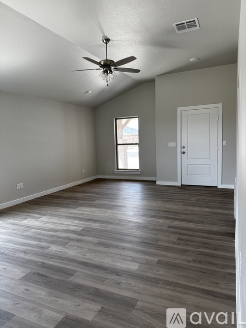A room with a ceiling fan and a door.