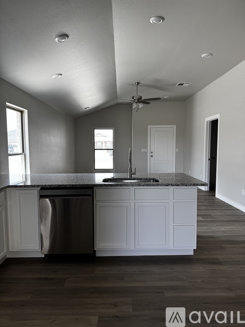 A kitchen with white cabinets and a stainless steel dishwasher.