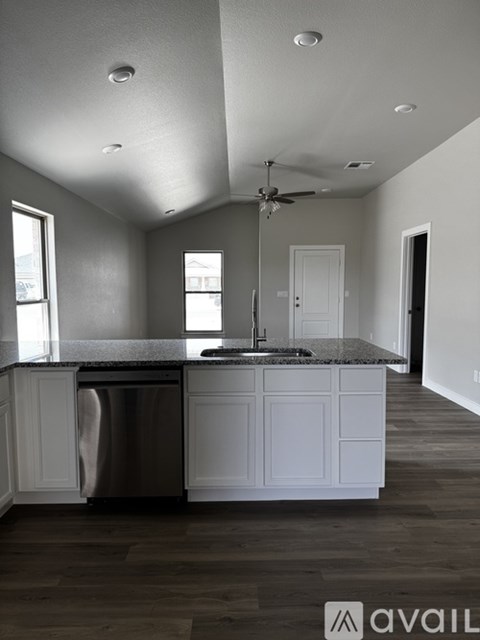 A kitchen with white cabinets and a stainless steel dishwasher.