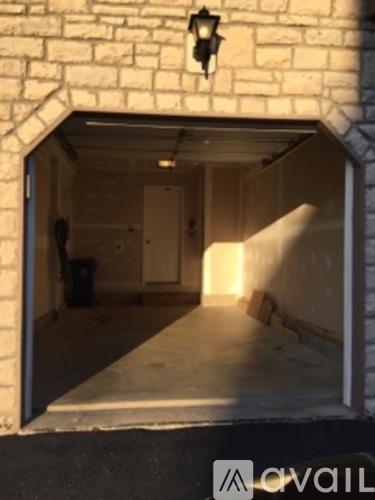 A stone wall with a light on it and a doorway.