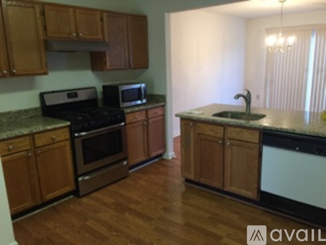 A kitchen with wooden cabinets and a granite countertop.