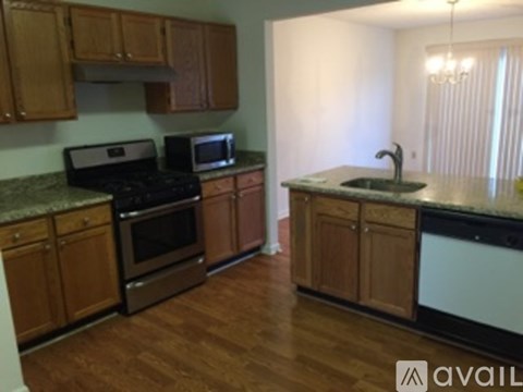 A kitchen with wooden cabinets and a granite countertop.