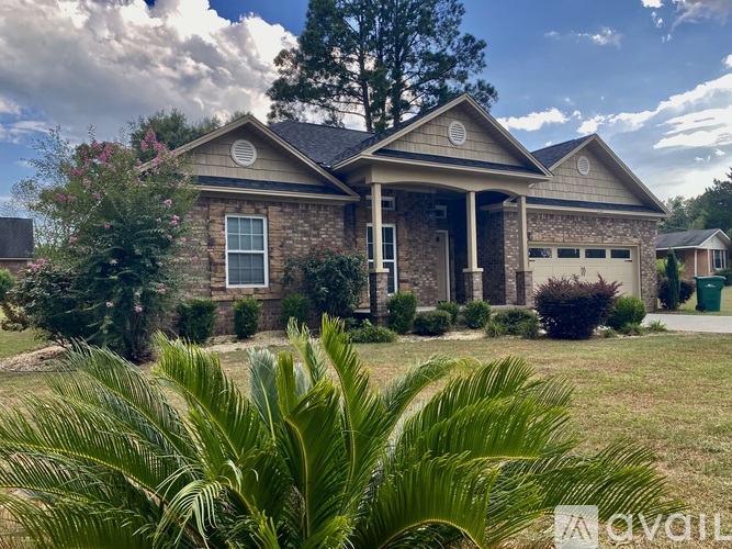 A house with a large front yard and a palm tree in the foreground.