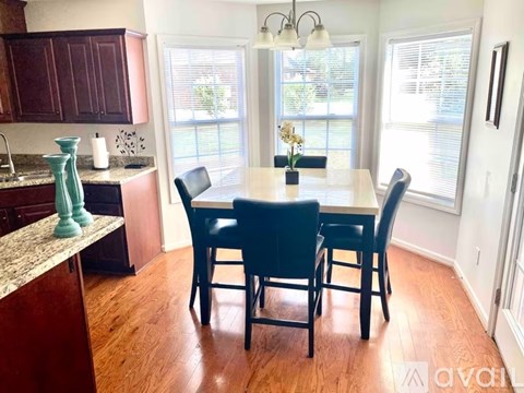 A kitchen with a table and chairs in the middle of the room.