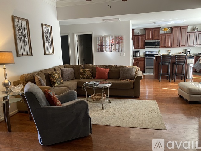 A living room with a grey couch and a grey armchair.