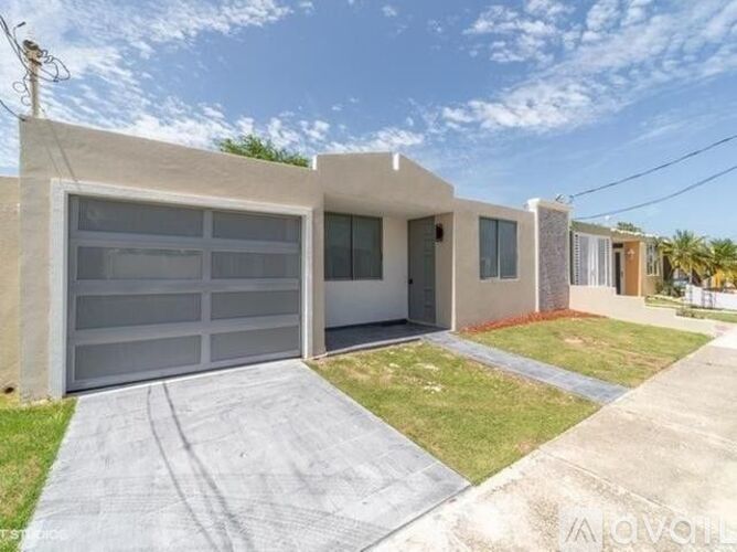 A modern house with a garage door and a driveway.
