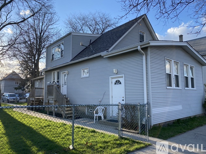 A grey house with a white door and windows.
