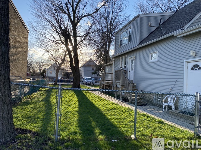 A residential area with houses and a tree in the foreground.