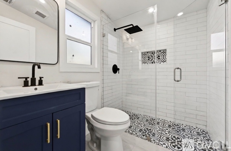 A white toilet sits in a bathroom with a blue cabinet.