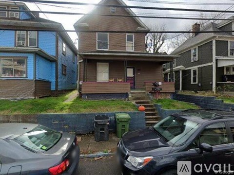 Two cars are parked in front of a house.