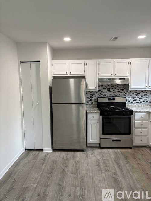 A kitchen with a stainless steel refrigerator, oven, and microwave.