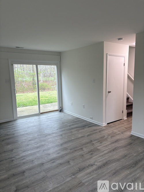 A room with a white door and a window with a view of the outside.