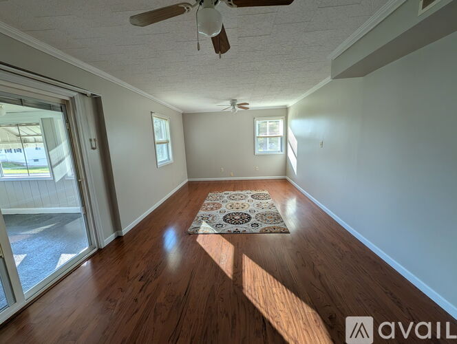A room with wooden floors and a ceiling fan.
