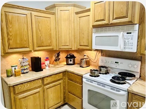 A kitchen with wooden cabinets and a white stove top oven.