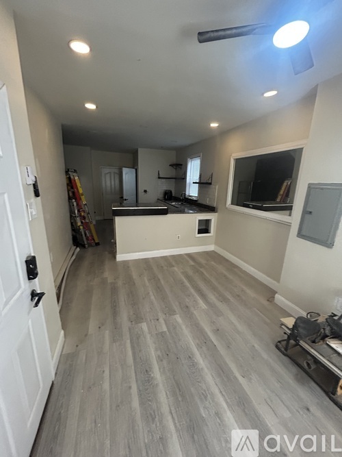 A room with a white door and a grey floor.