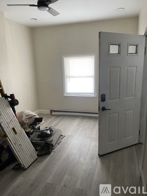 A room with a door, a window, and a ceiling fan.
