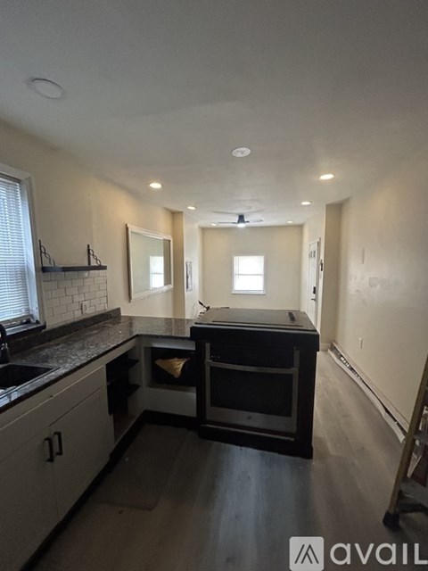 A kitchen with a black countertop and a sink.