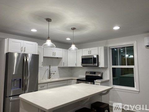 A modern kitchen with white cabinets and stainless steel appliances.