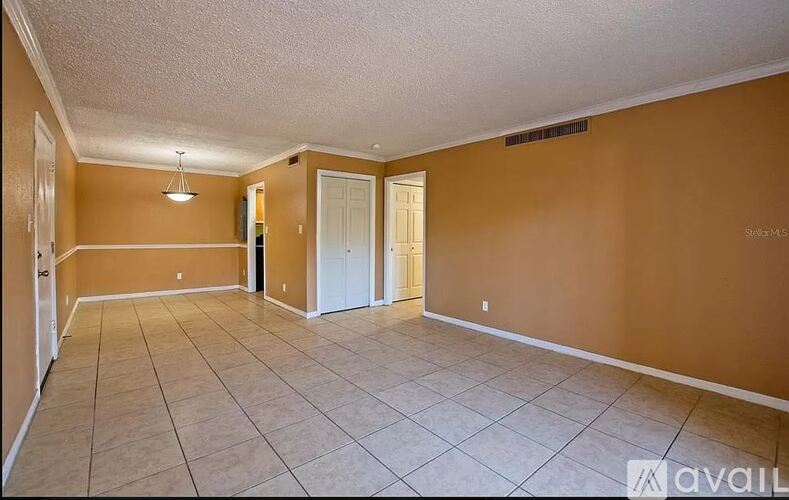 Empty room with tile flooring and two doors.