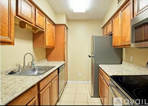 A kitchen with wooden cabinets and a granite countertop.