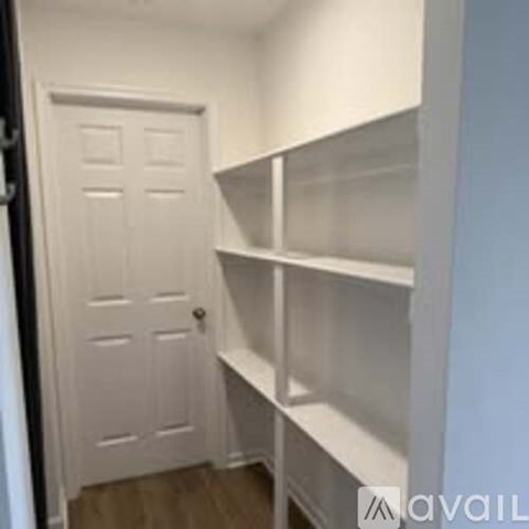 A white door is on the left and a white shelf is on the right.
