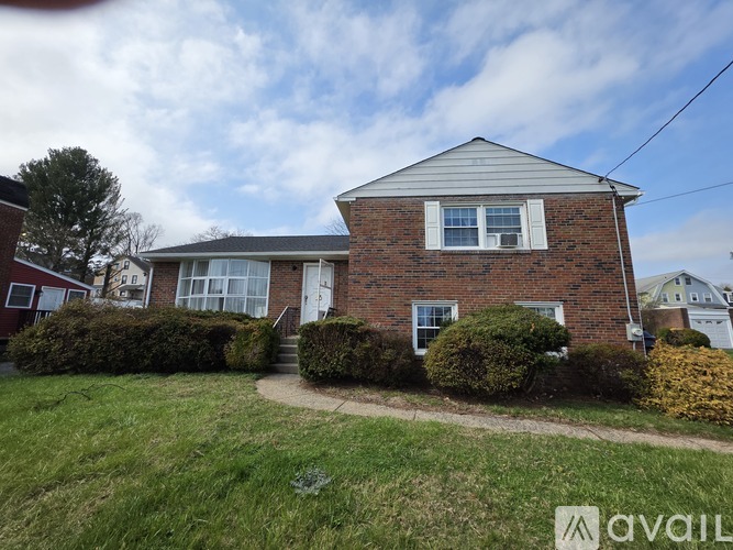 A house with a brick facade and a grey roof is for sale.