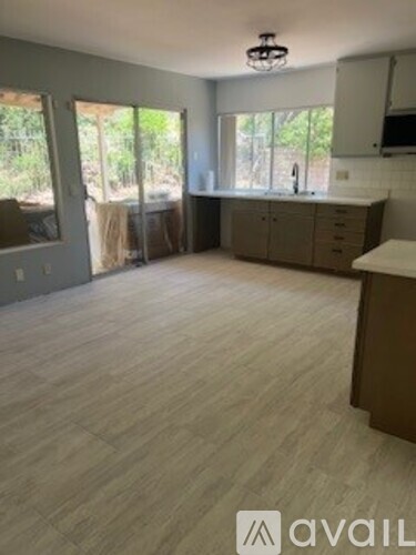 A kitchen area with a counter and cabinets is visible.