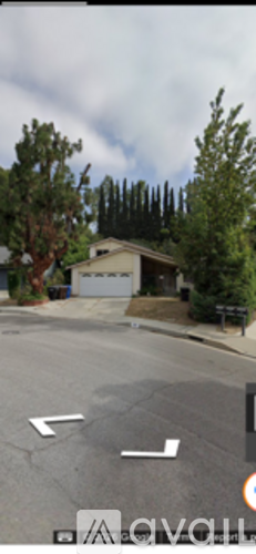 A house with a garage is surrounded by trees.