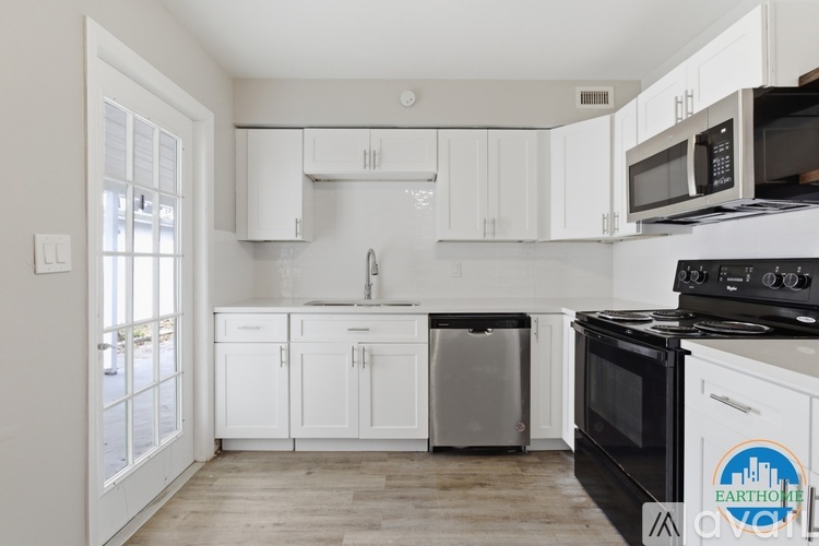 A kitchen with white cabinets and a black stove top oven.