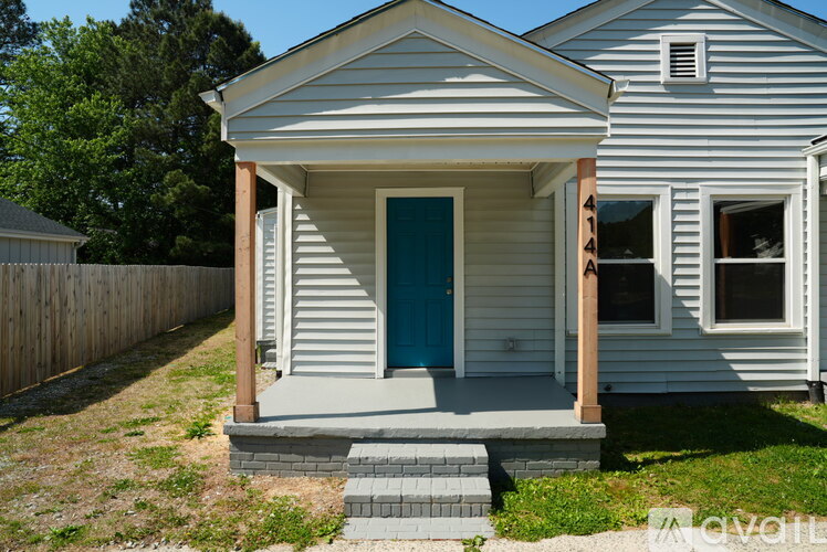 A small house with a blue door and a porch.