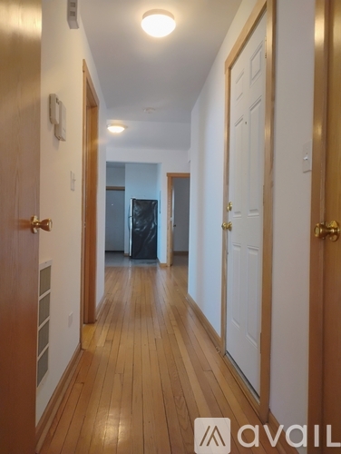 A hallway with wooden floors and white walls.