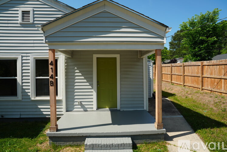 A small house with a green door and a wooden porch.