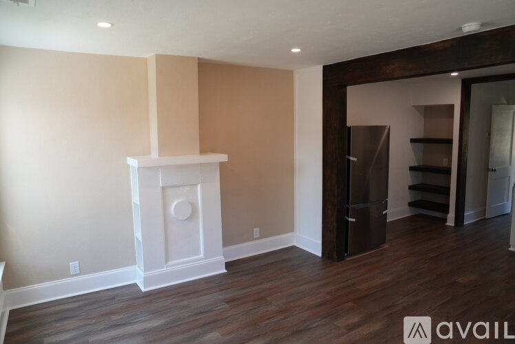 A living room with a fireplace and wooden floors.
