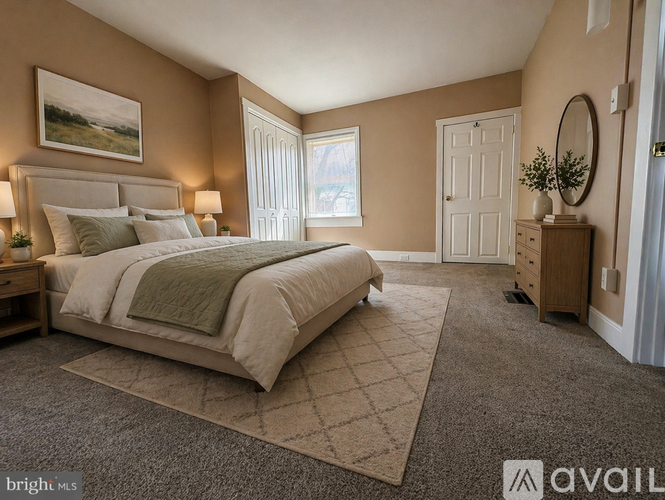 A bedroom with a large bed and a window with blinds.