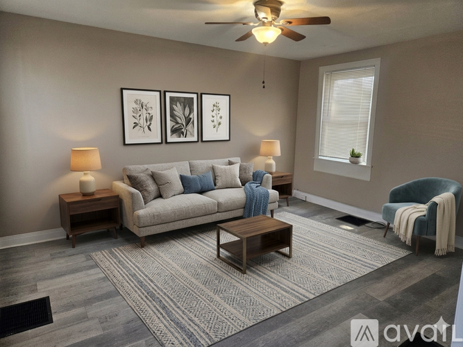 A living room with a grey sofa, a wooden coffee table, and a ceiling fan.