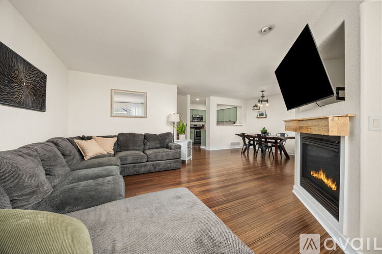 A living room with a grey sofa and a fireplace.