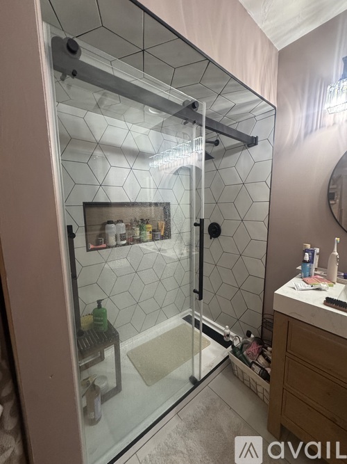 A bathroom with a glass shower door and a white sink.