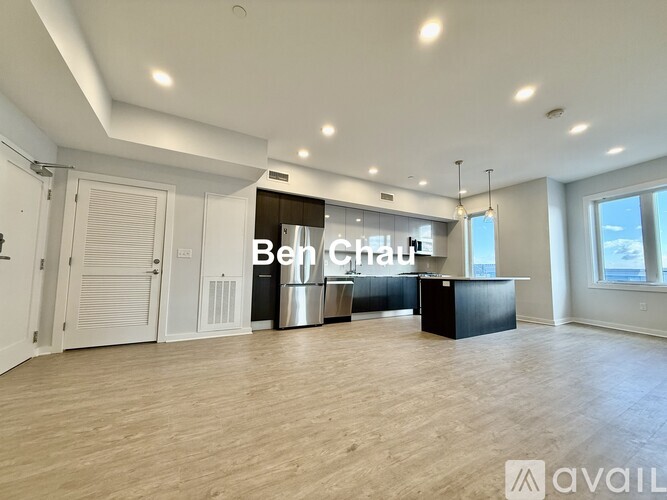 A spacious room with wooden flooring and a sign that reads "Ben Chau".