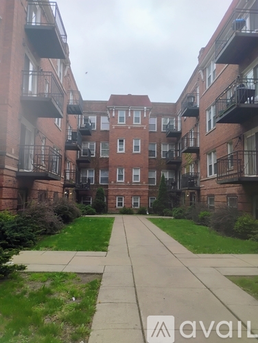 A long concrete walkway leads to a brick building with balconies.