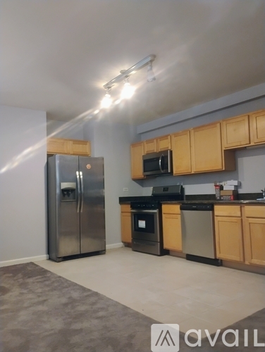 A kitchen with wooden cabinets and a refrigerator.